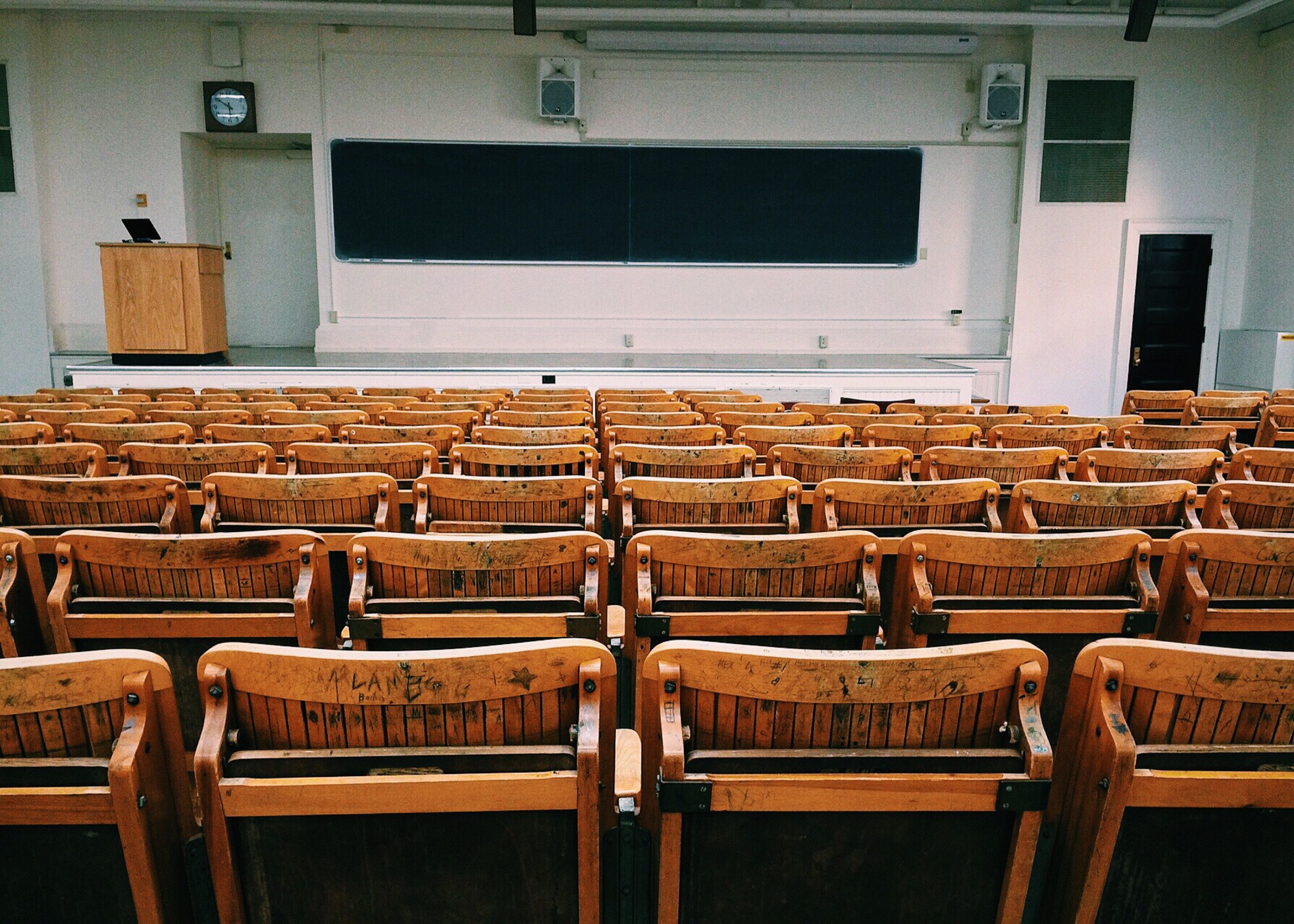An empty classroom with wooden chairs