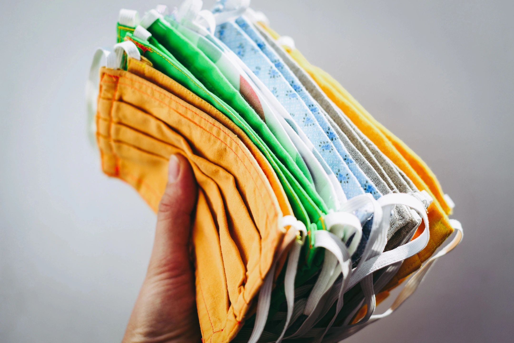 hand holding handful of cloth face masks