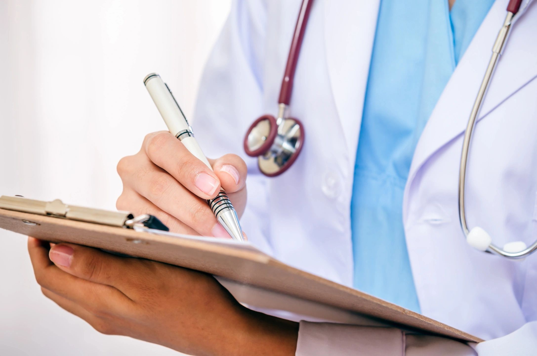 doctor holding clipboard and writing