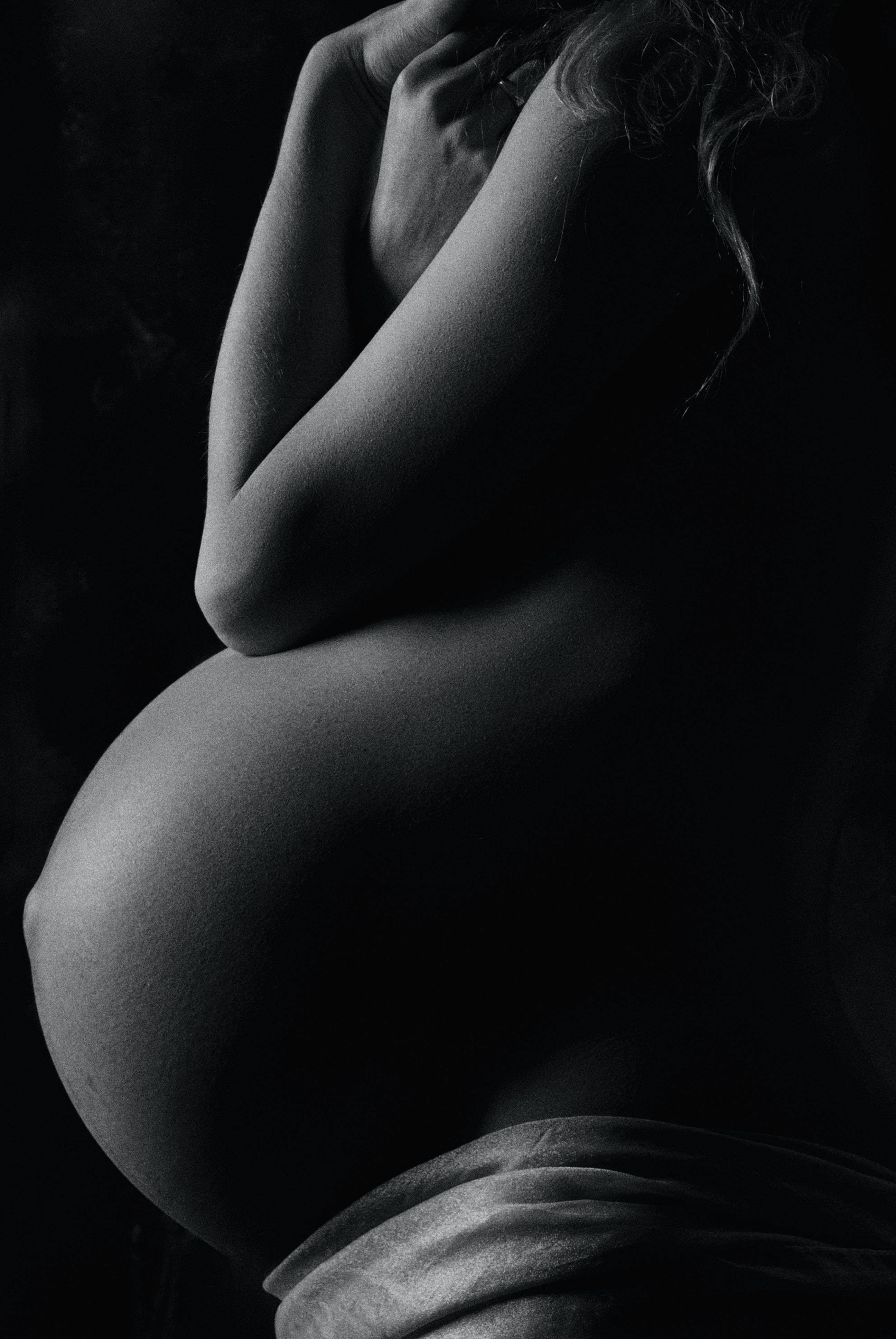 Black and white image of bare pregnant belly
